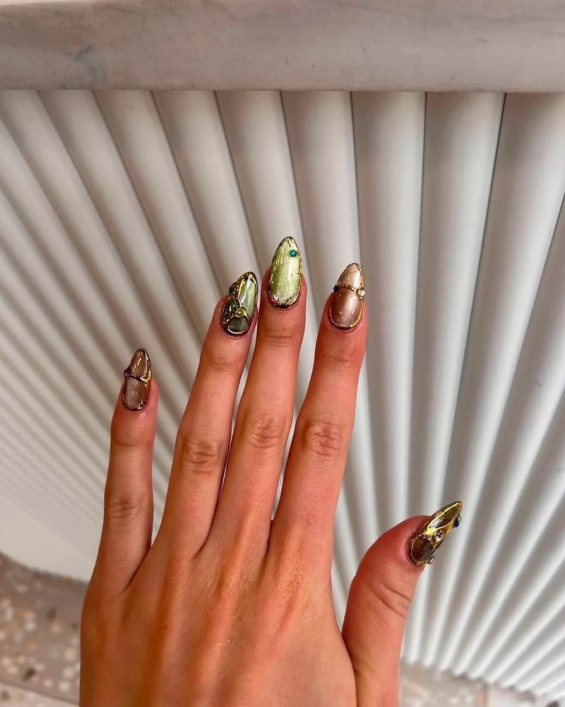 Long nails in gold chrome with a sculpted gold accent