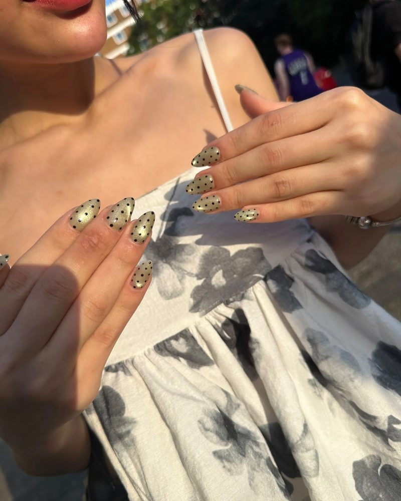 Gold flecked nude nails photographed outdoors